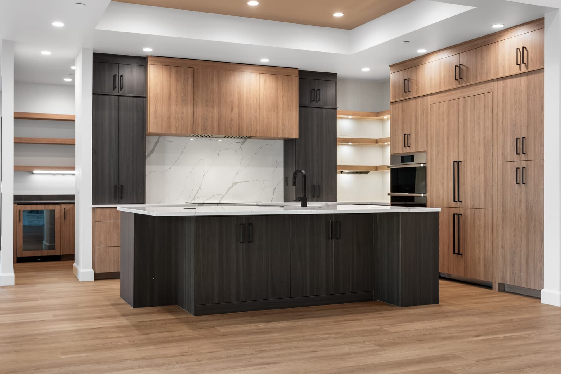 Open kitchen with large island and designer finishes by Kiefer Built Contracting