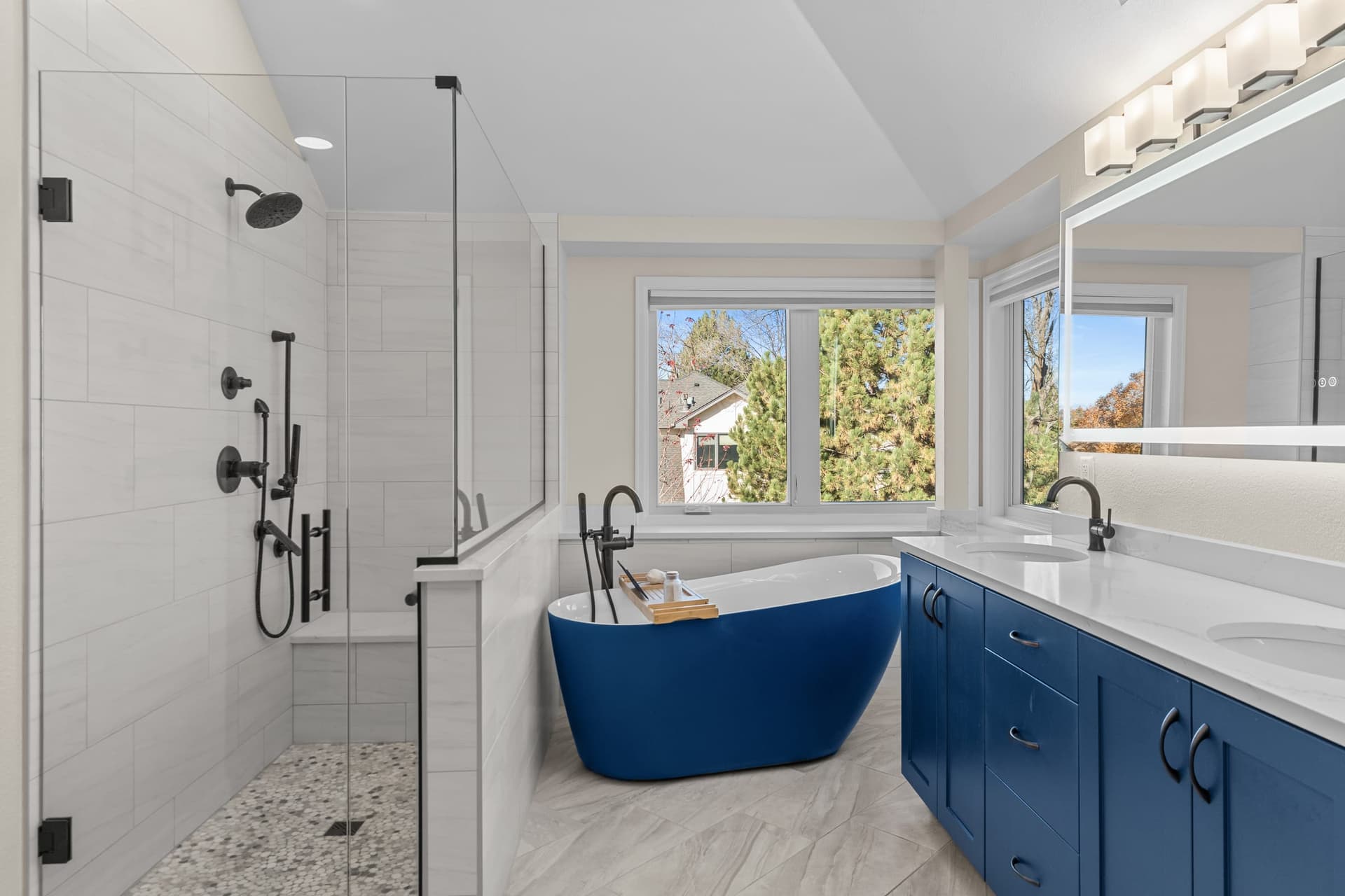 Bathroom with blue soaking tub and shower by Kiefer Built Contracting