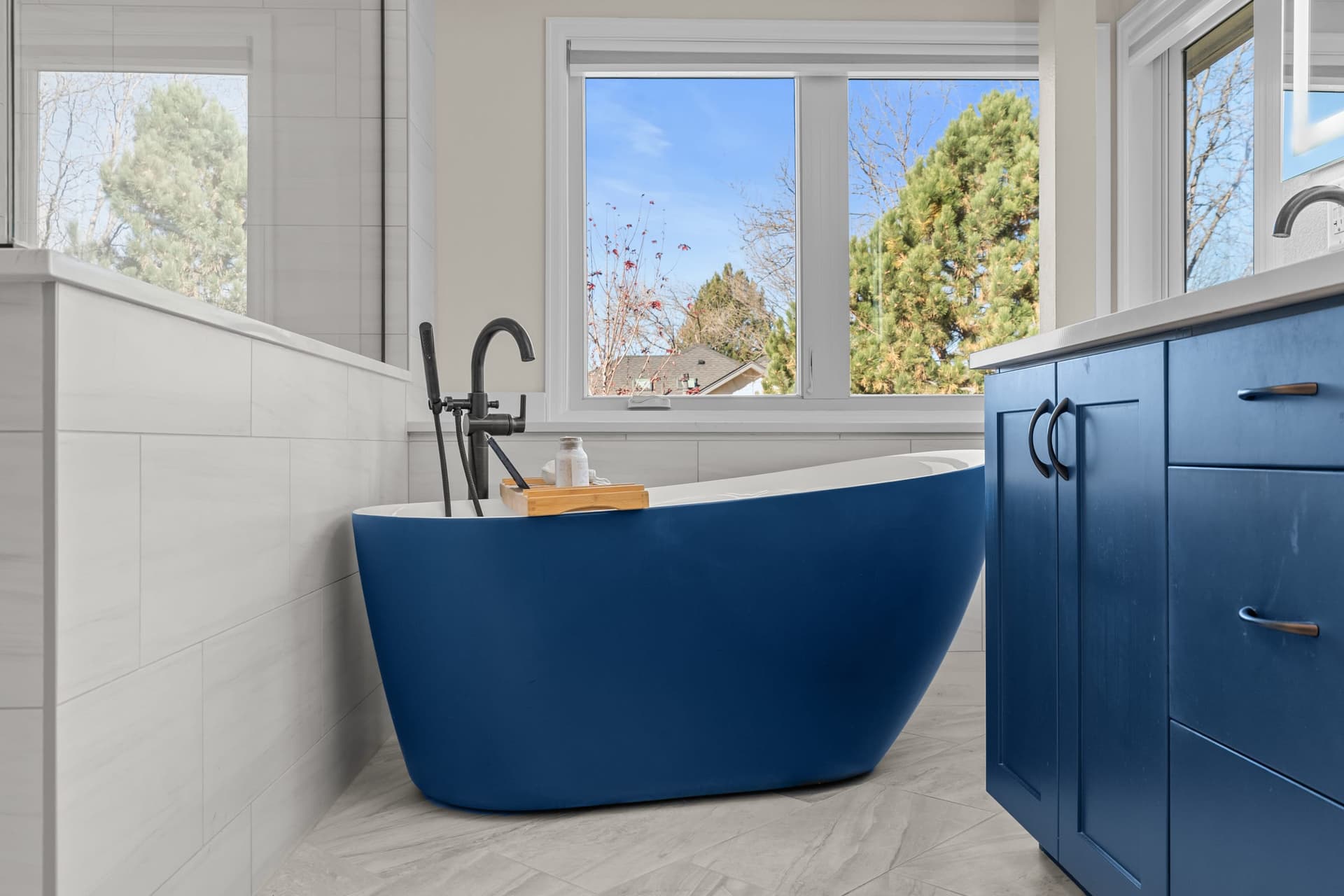 Bathroom soaking tub and blue cabinetry by Kiefer Built Contracting