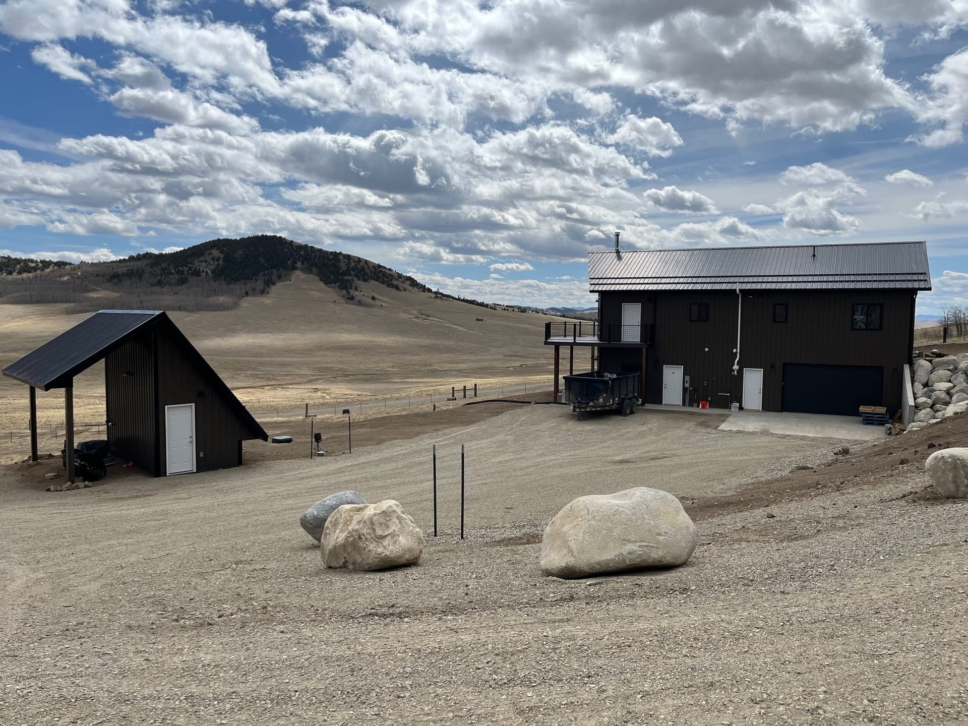 Gravel driveway with boulder accents, solar shed, and mountain vista
